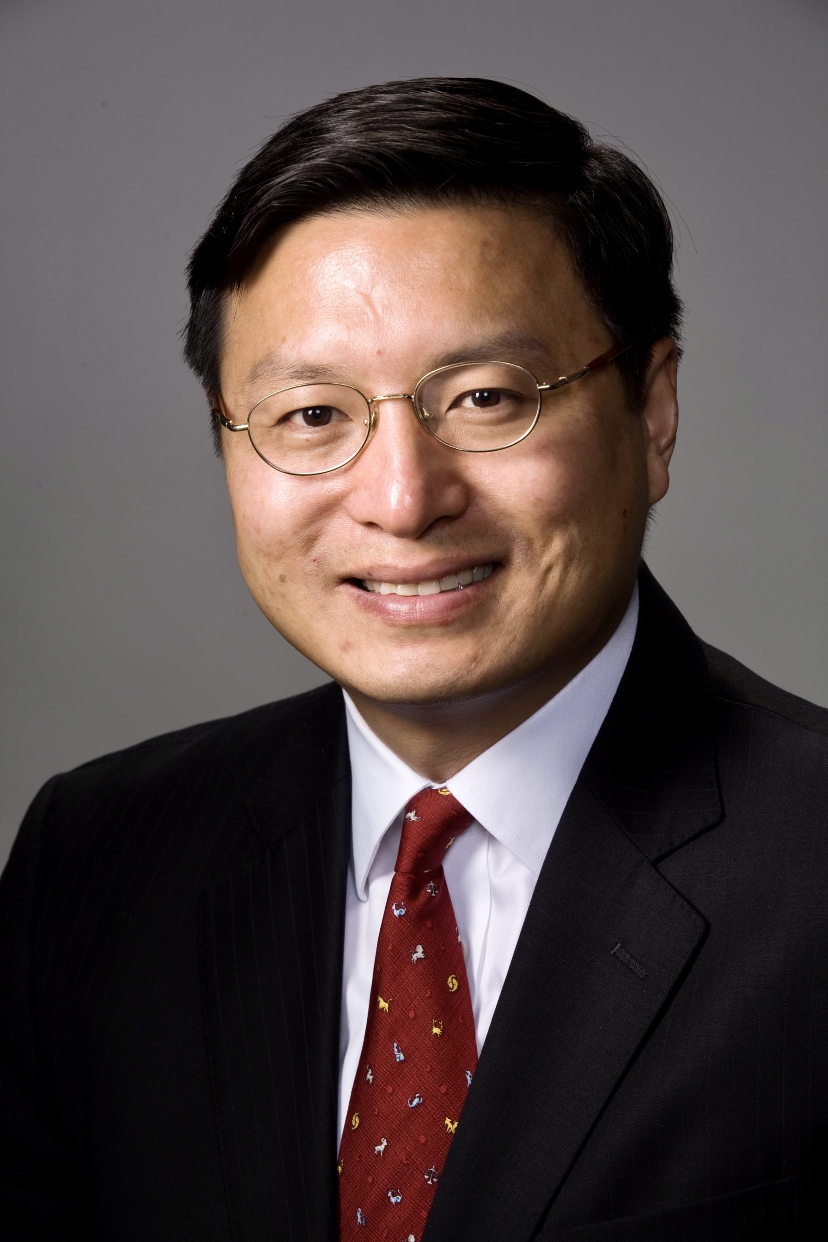 A man in a suit and tie smiling for the camera.