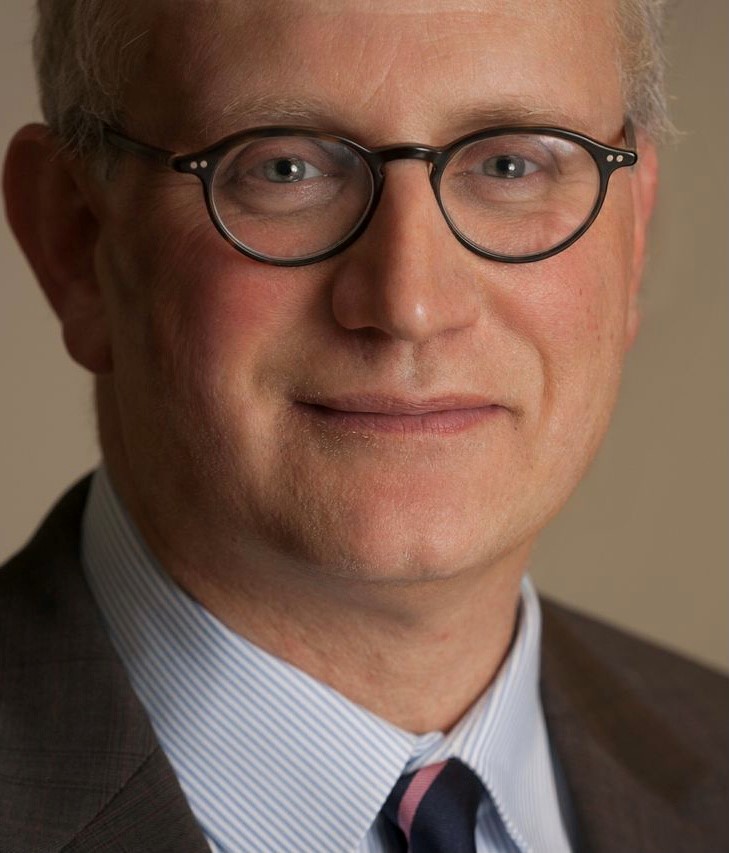 A man with glasses and a suit on.